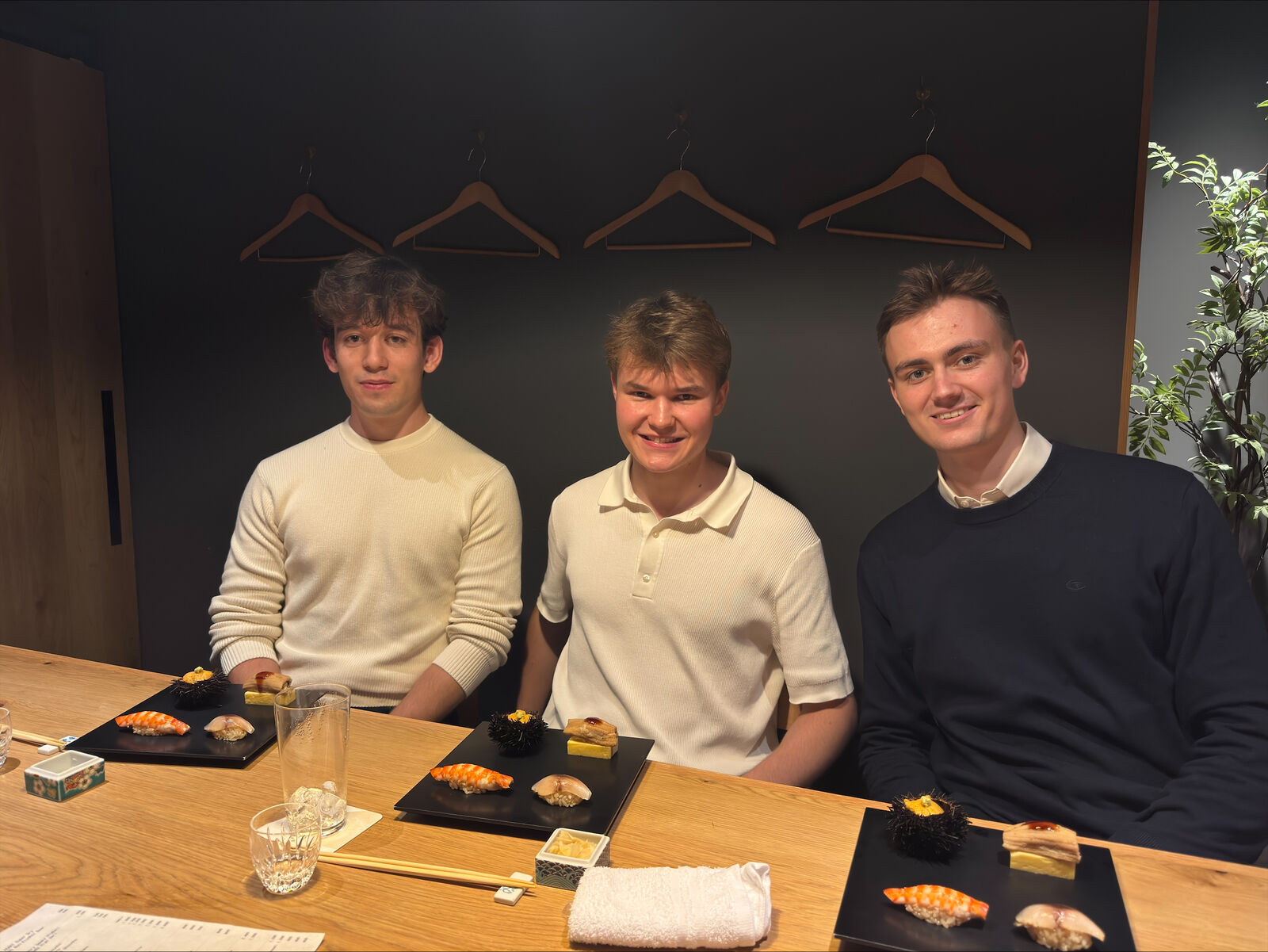 The three members of LMU Investment Club at a sushi counter in Tokyo